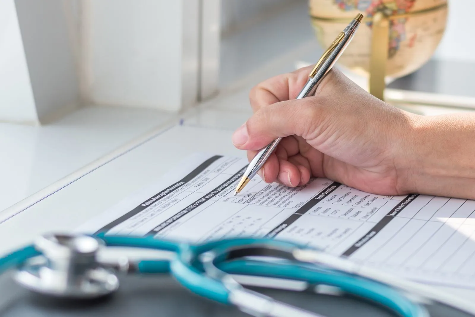 Patient record being filled in beside a stethoscope