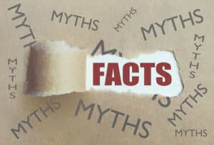 Torn brown paper revealing the word facts surrounded by myths