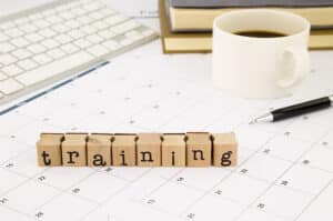 Wood blocks sitting on a desktop calendar spell the word training